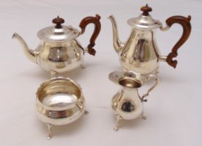 A hallmarked silver four piece tea and coffee set of compressed circular form with scroll handles