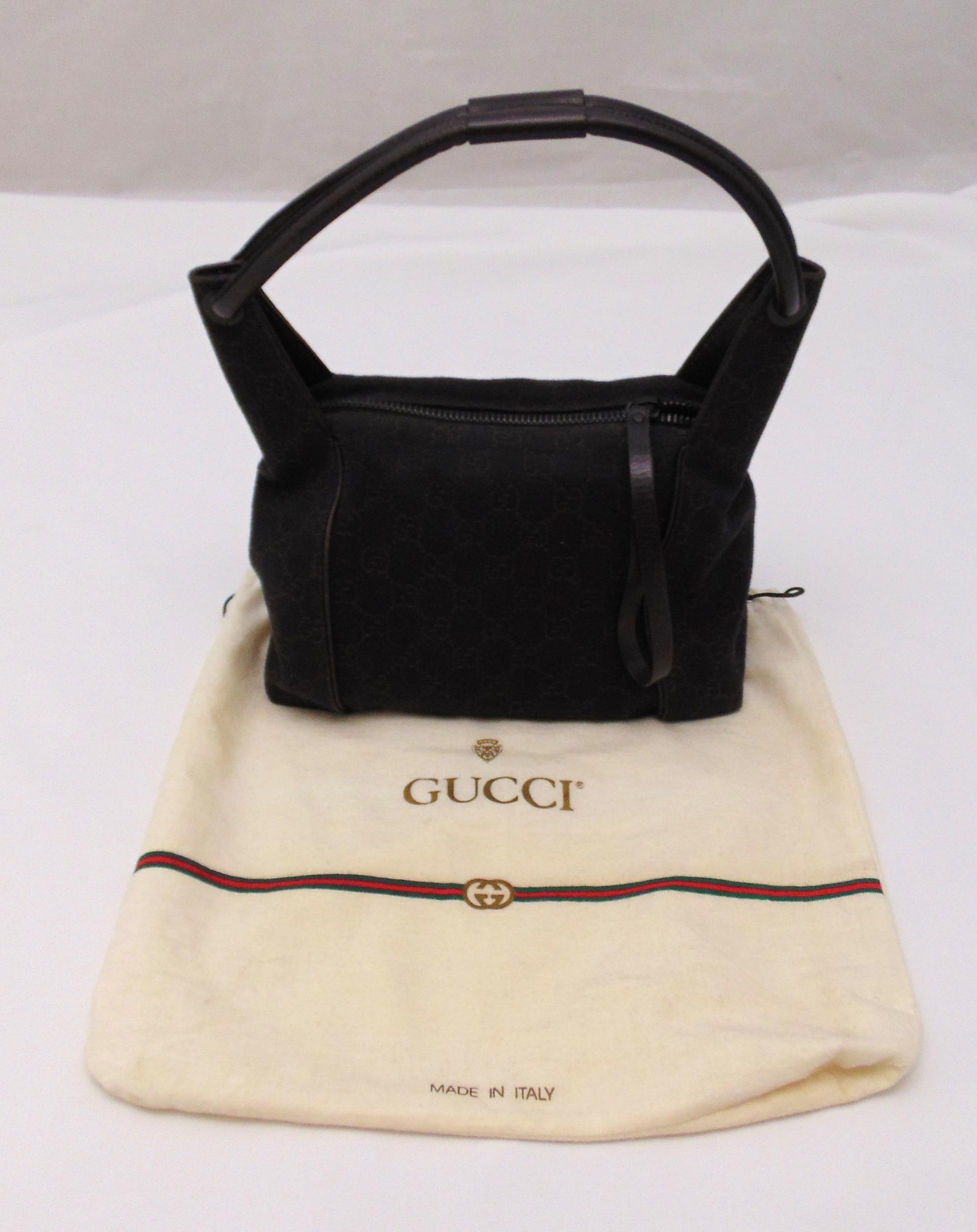 A vintage Gucci ladies fashion material handbag with leather strap handle and cloth cover