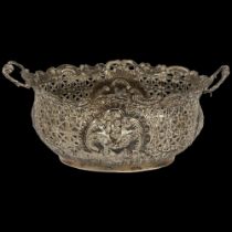 An ornate Victorian silver 2-handled table basket, with allover embossed and pierced decoration,