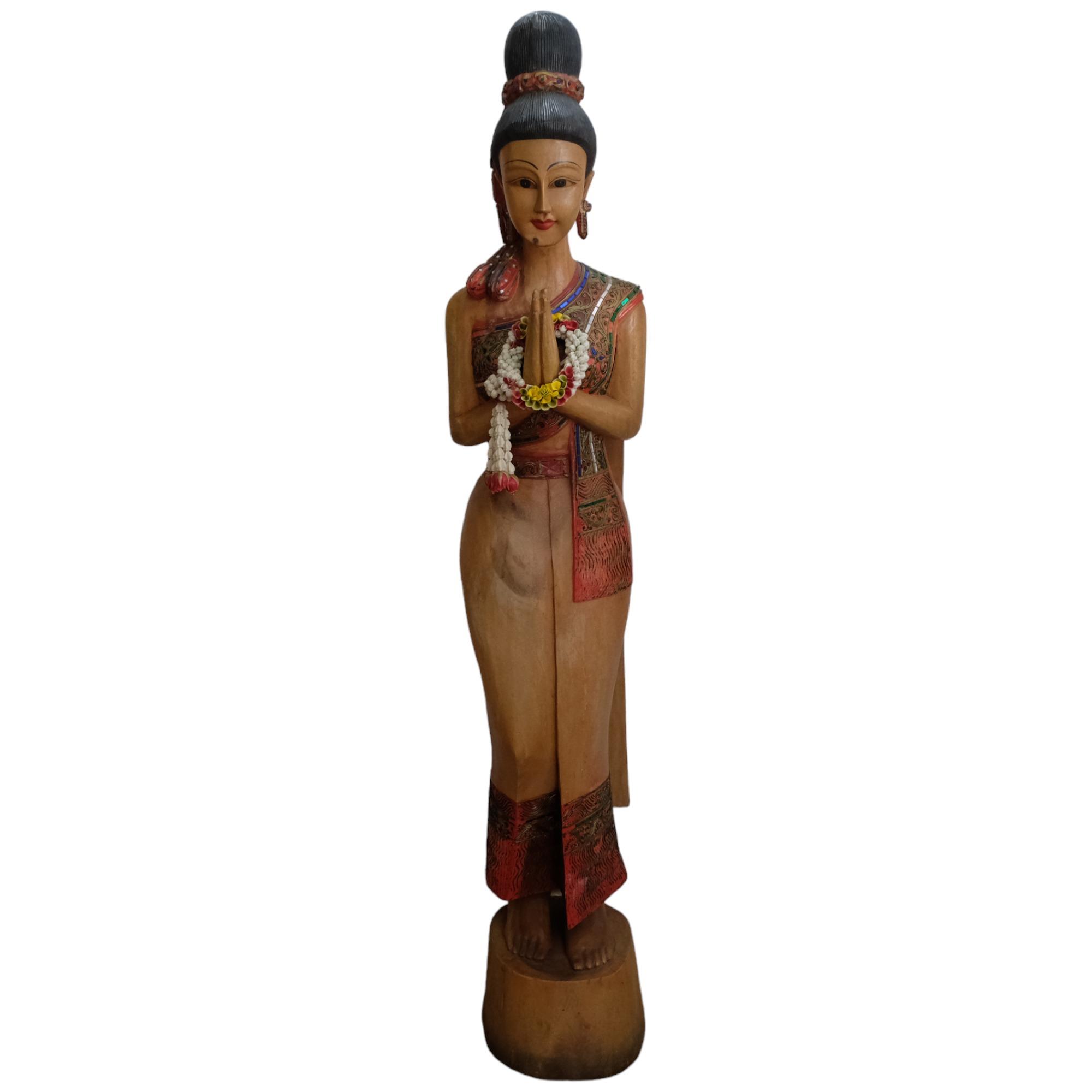 A Thai carved and painted wood figure of a Sawasdee female. H - 152cm.