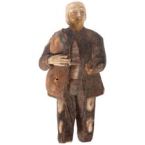 An antique Folk Art carved wood and bone figure of a man playing the bagpipes. H - 15cm. Missing