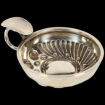 A small French silver wine taster, with relief embossed decoration, indistinct maker's mark, bowl