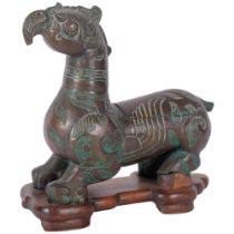 An Oriental verdigris bronze mythical beast, on fitted wooden stand, H23cm