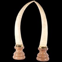 A pair of composition Scrimshaw style tusks on plinths, H76cm