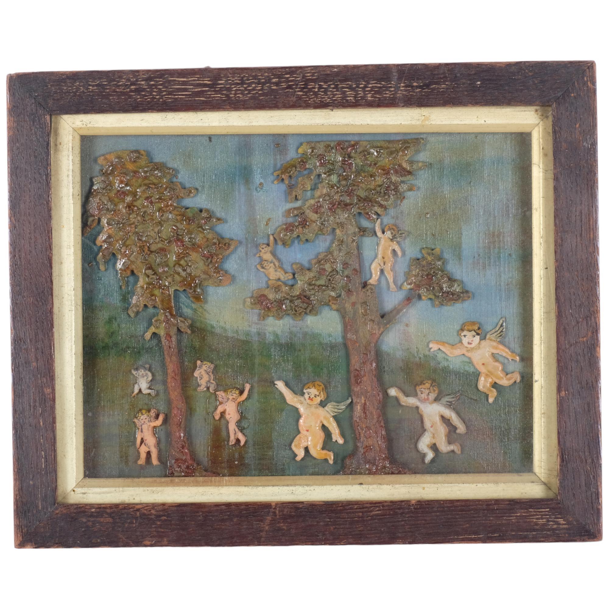 A carved and painted wood/wax relief picture, depicting trees and cherubs in glazed frame, 21cm x