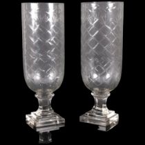 A pair of cut glass hurricane lanterns on square plinths. H - 34cm.