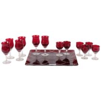 A suite of 6 ruby Sherry glasses, and 6 ruby glass liqueur shot glasses, on an Art Deco style ruby