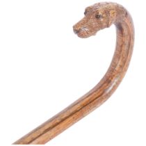 A 1-piece carved hounds head stick, with inset glass eyes. L - 87cm.