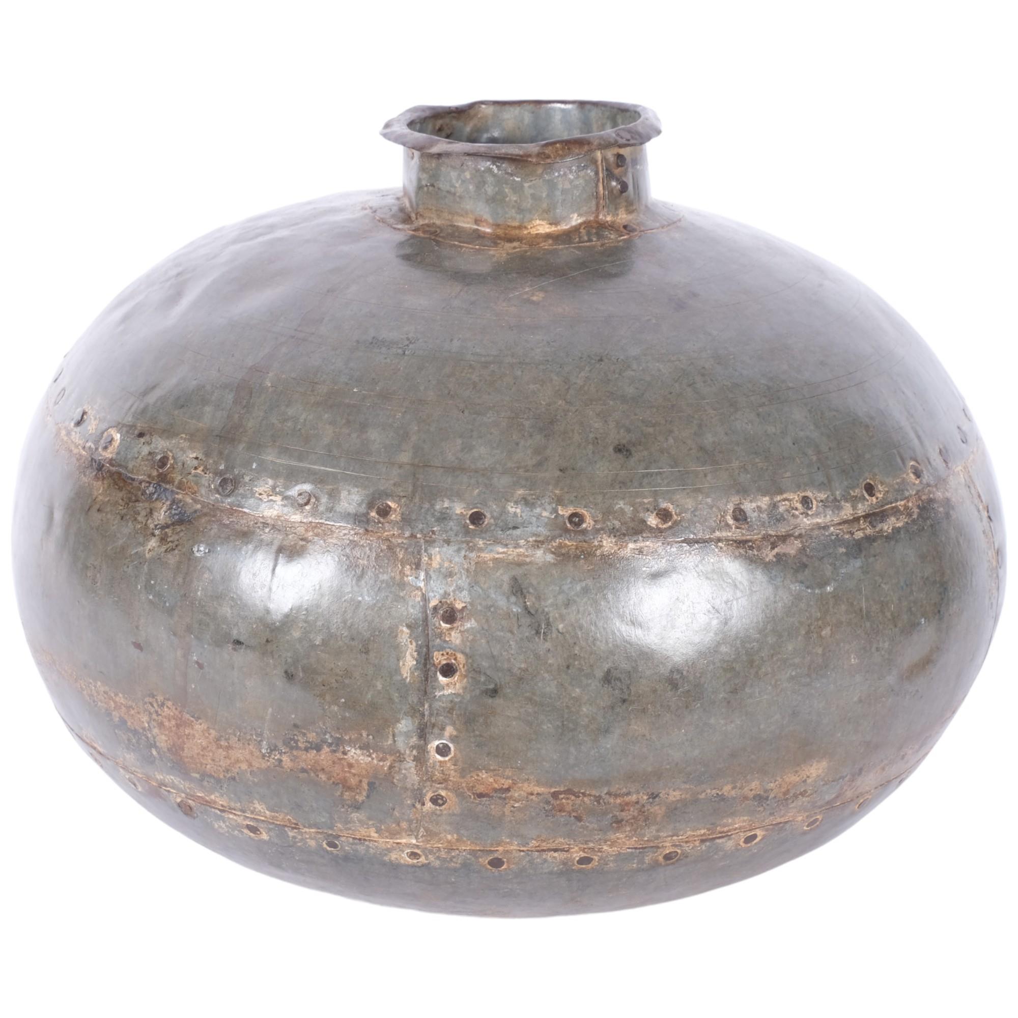 A studded metal industrial vase. 35cm diameter