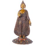 An Oriental embossed and gilded bronze standing Buddha figure, H27cm