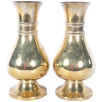 A pair of heavy brass vases on feet, 25.5cm