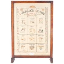 A 1937 Coronation calendar needlework, in the form of a fire screen, wooden frame with glass