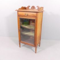 An antique mahogany music cabinet, with single drawer above glazed door. 58x111x36cm.