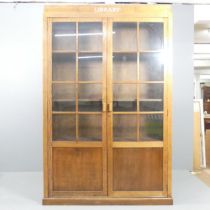 An early 20th century oak bookcase, with two lattice glazed doors revealing four shelves (two