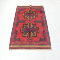 A red-ground Baluchi rug. 140x79cm.