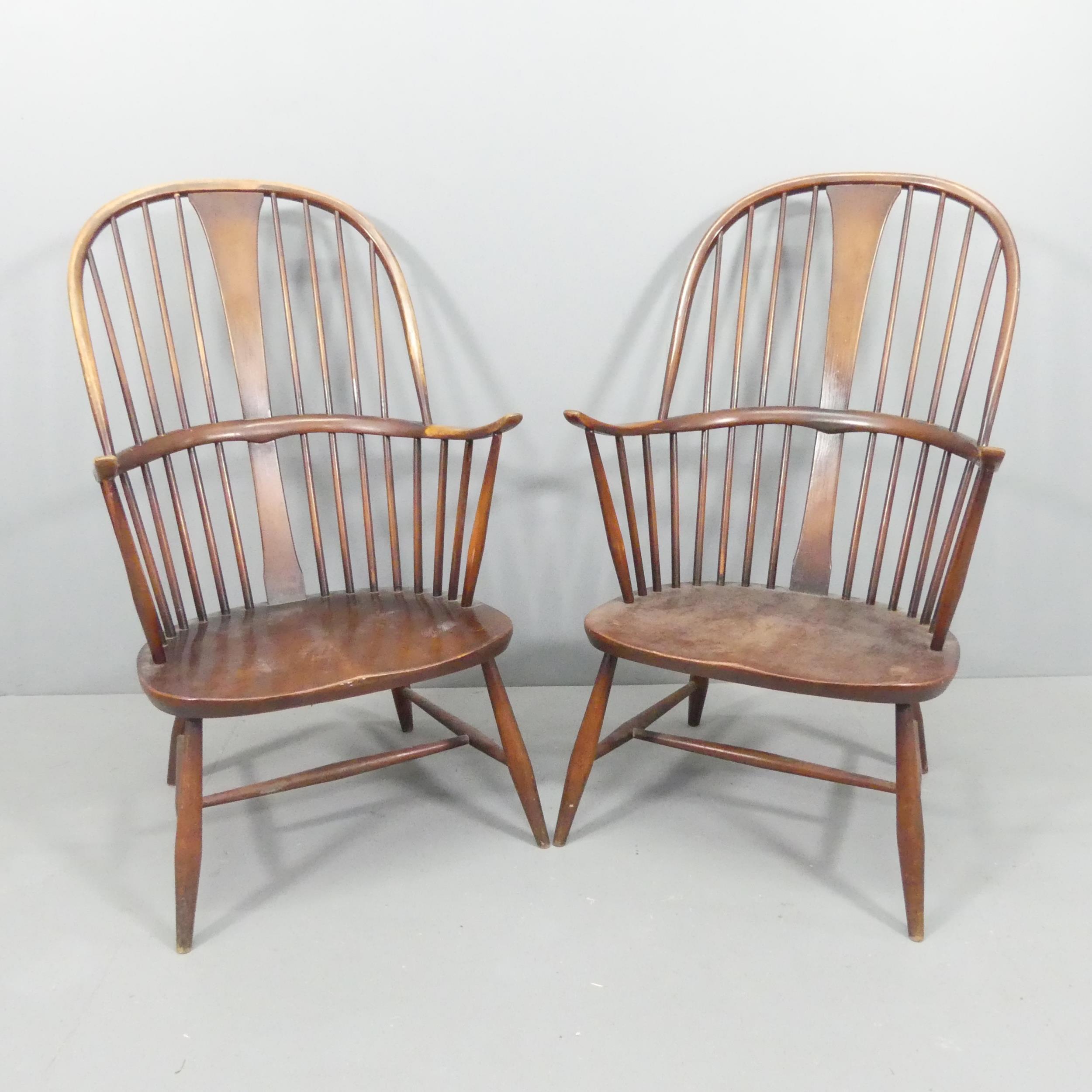 ERCOL - a pair of mid-century Chairmaker's comb-back elbow chairs. With maker's labels.