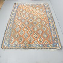 A red-ground Kilim carpet. 240x175cm Some loss to fringes, some holes. Please see additional