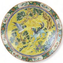 19th century Chinese porcelain charger, with painted mythical beast and bird of prey on yellow