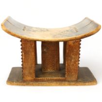 An antique Ashanti stool, Ghana, with carved central column and supports, length 43cm, height 30cm
