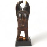 A Baule, Ivory Coast weaving pulley, carved wood masked figure on wooden plinth, height 16cm Break