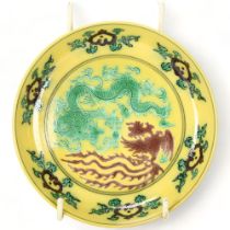 A Chinese yellow glaze porcelain dish, with incised dragons, 6 character mark, diameter 13.5cm