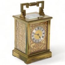 A French brass-cased carriage clock, the front and side panels having pierced and engraved copper