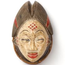 A Punu, Gabon wood carved and painted female mask, with woven raffia border, height 30cm Good