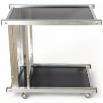A 1970s' brushed steel and smoked glass two tier serving trolley, on casters, height 64cm, 70 x 42cm