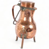A large Antique Art Nouveau hammered copper water jug, on 3 feet, with swing handle, H37cm