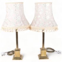 A pair of Classical design cast-brass table lamps with reeded columns, and matching cream shades,