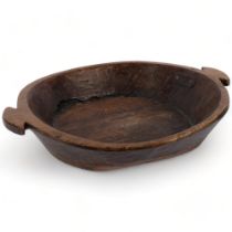 A large hand carved polished wood dough or fruit bowl, 45cm diameter