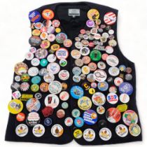 A large collection of Vintage badges, mounted on a waistcoat, including the Beano, Dennis the Menace