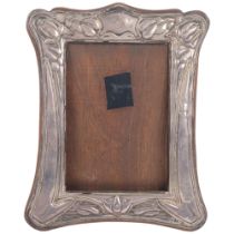 An Art Nouveau silver-fronted photo frame, indistinct hallmarks, relief embossed floral