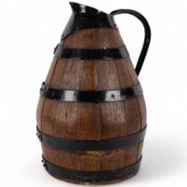 A large coopered oak jug, with metal loop handle and spout, H46cm