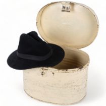 A Vintage hat tin, 37cm across, containing a black hat