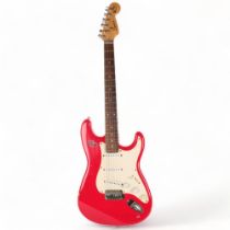 A Squire Strat by Fender electric guitar, red body, serial no. YN732177, head is signed but