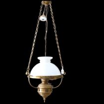A brass oil lamp style electric light, with milk glass shade and chains, 35cm across