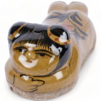 An Oriental ceramic glazed pillow in the form of a figure, L26cm