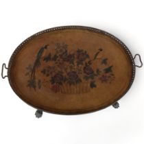 An oval galleried tea tray on paw feet, with embossed and painted fabric panel depicting birds and