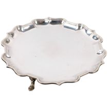 An Edwardian circular silver salver, CS Harris & Sons Ltd, London 1904, scalloped rim, raised on 3