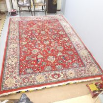 A red-ground Persian Sarouk carpet. 320x220cm. Some fading and marks visible.