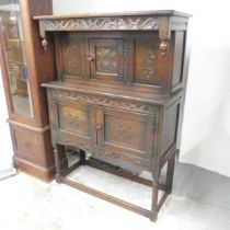 An oak low court-cupboard, with panelled and applied carved decoration. 100x136x40cm. Good