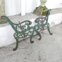A pair of painted cast iron bench ends, with leopard head terminals. Height 74cm.