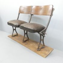 A pair of vintage folding leather upholstered cinema seats mounted on wooden plate. Overall
