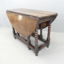 An antique oak oval gate-leg table, with bobbin turned legs. 106x73x43cm (opening to 125cm). Top