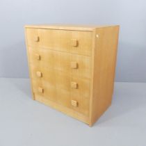 A mid-century light oak chest of four long drawers, with label for Herbert E. Gibbs ltd. to back.