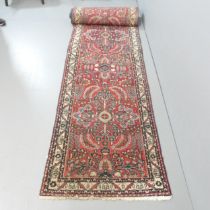 A red-ground Afghan runner. 610x83cm