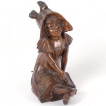 A late 19th century carved wood figure of a seated girl with a book, in the Art Nouveau style, H31cm
