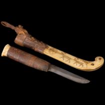 An Inuit carved bone knife and leather-mounted sheath, sheath decorated with caribou, blade length