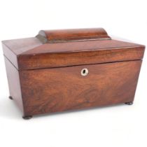A Regency rosewood tea caddy of sarcophagus form, on bun feet, with fitted inner lids and mixing